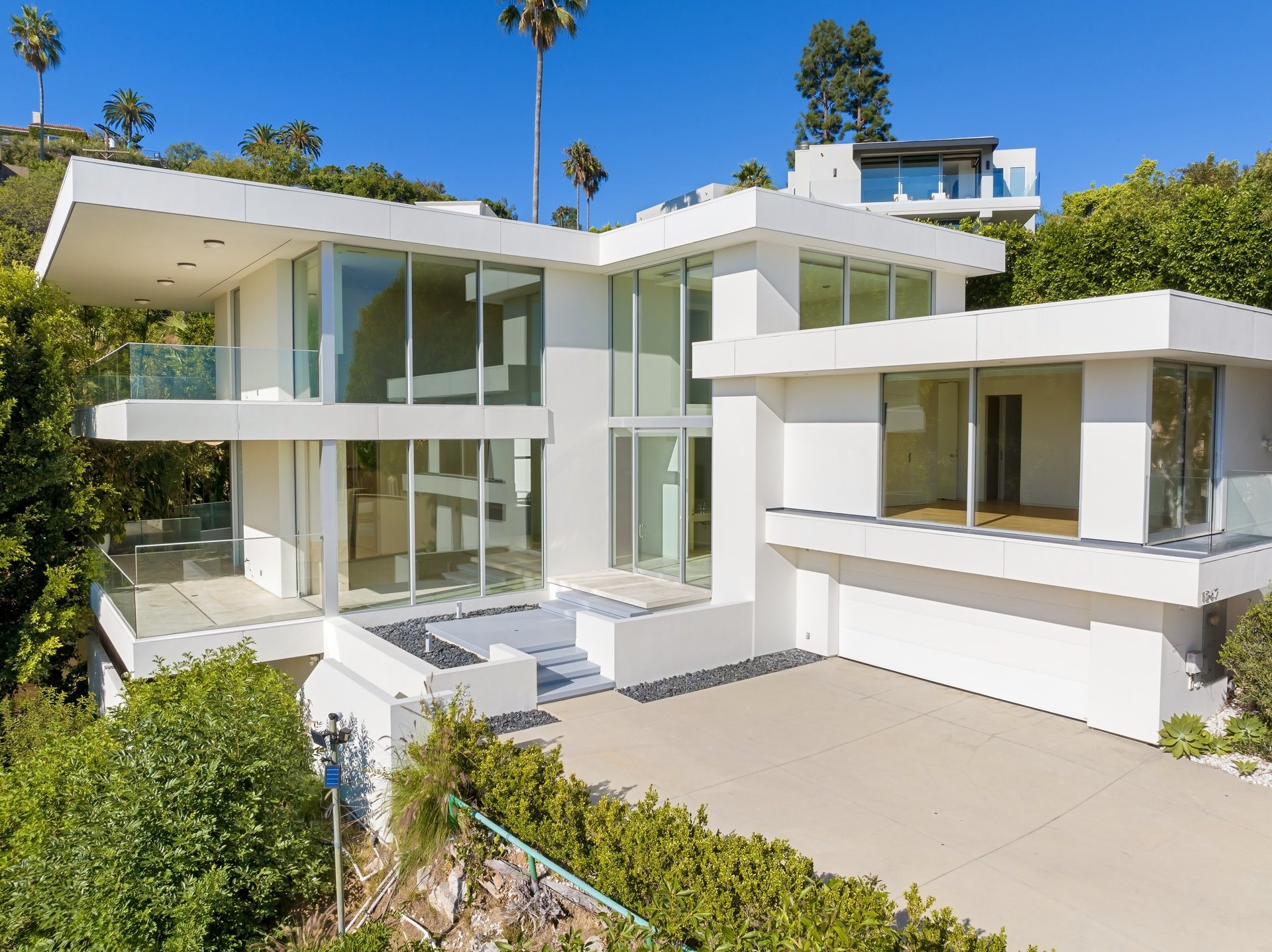 A Contemporary hillside home with large aluminium glass windows and doors showcased from a distance