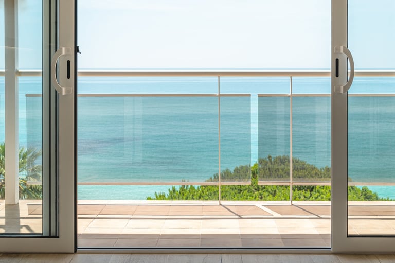 Sliding glass doors on balcony overlooking sea and Cape Town coastline